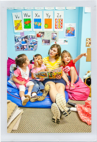 Photograph: A child care professional reads with a group of children