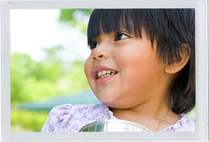 Photograph: A female toddler smiles at something or someone out of framee. (Photograph by Alex Lazara)