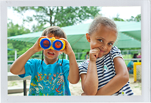 Photograph: A pair of preschool aged friends pose with a pair of toy binoculars. (Photograph by Alex Lazara)
