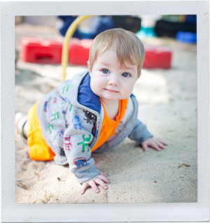 Photograph: An infant girl crawls in a sandbox. (Photograph by Alex Lazara)