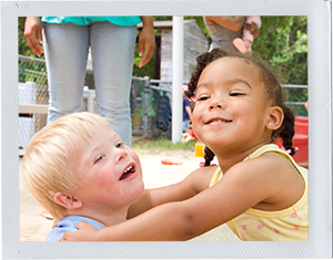 Photograph: A girl toddler embraces a boy toddler on a playground. (Photograph by Alex Lazara)