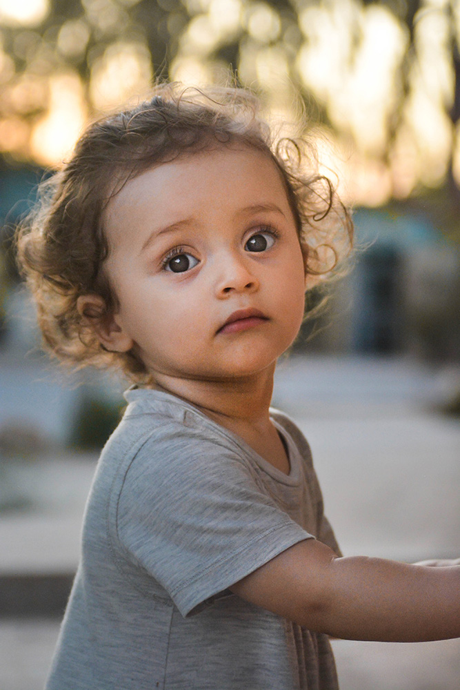 A toddler in a grey t-shirt gazes at the camera. (Pexels, Ali Meddah)