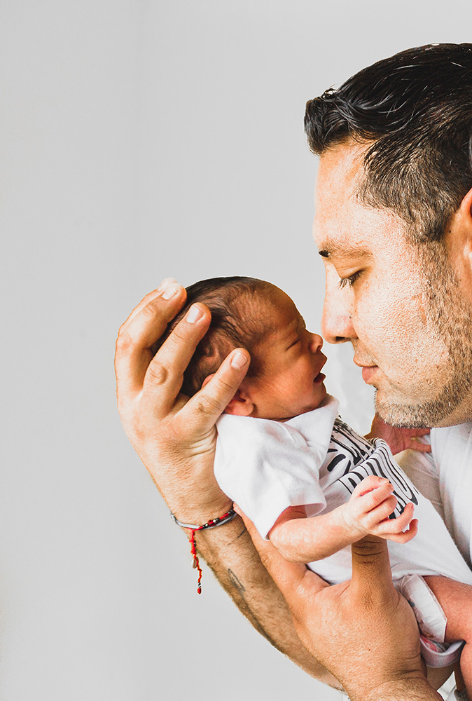 Photograph: A man cradles a newborn baby in his arms (Pexels, Laura Garcia).