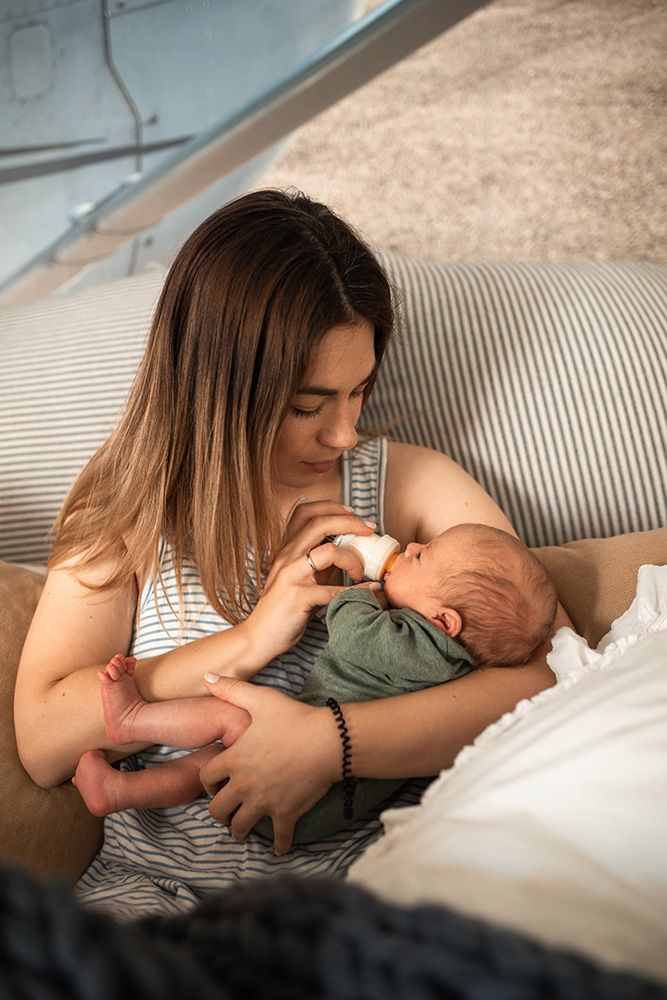 Photograph: A woman feeds a baby with a bottle (Pexels, RODNAE Productions).