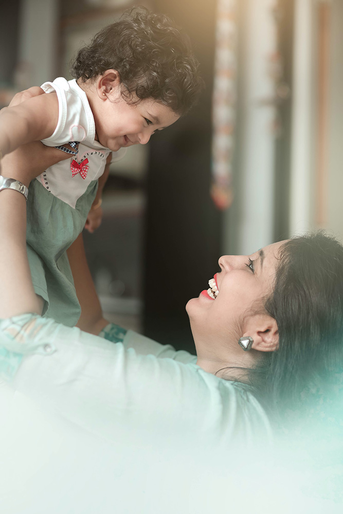 Photograph: A woman lifts a baby over her head, both are smiling (Pexels, The Weddingfog)